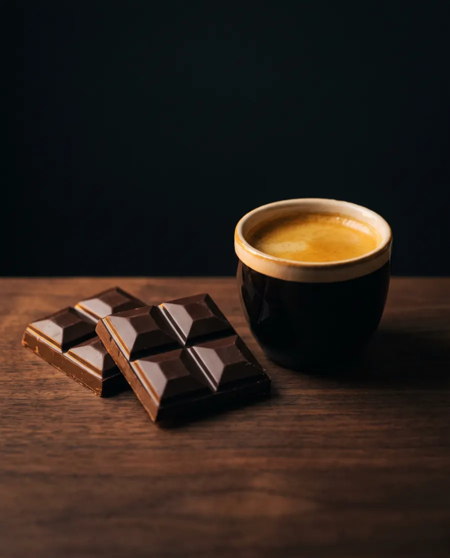 Cuadros de chocolate junto a una taza de espresso