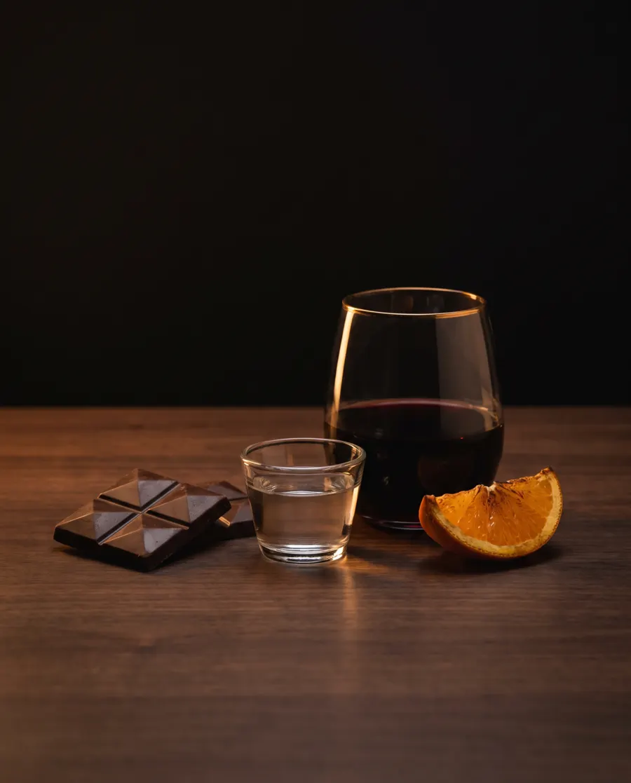 Chocolate con una copita de mezcal, vino tinto y naranja